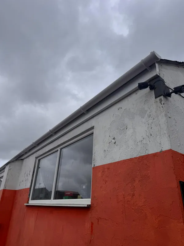 Commercial gutters and downpipes after cleaning — bright white finish