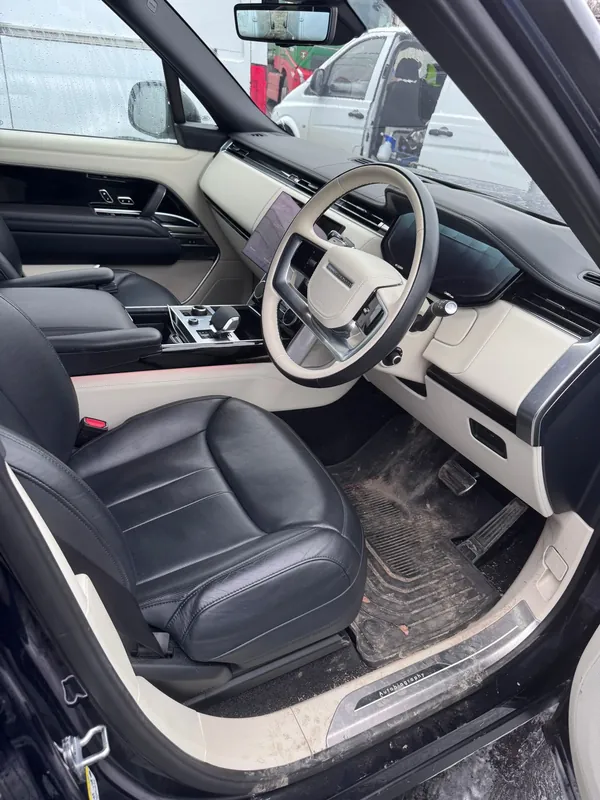 Range Rover interior before valet — dirty floor and console