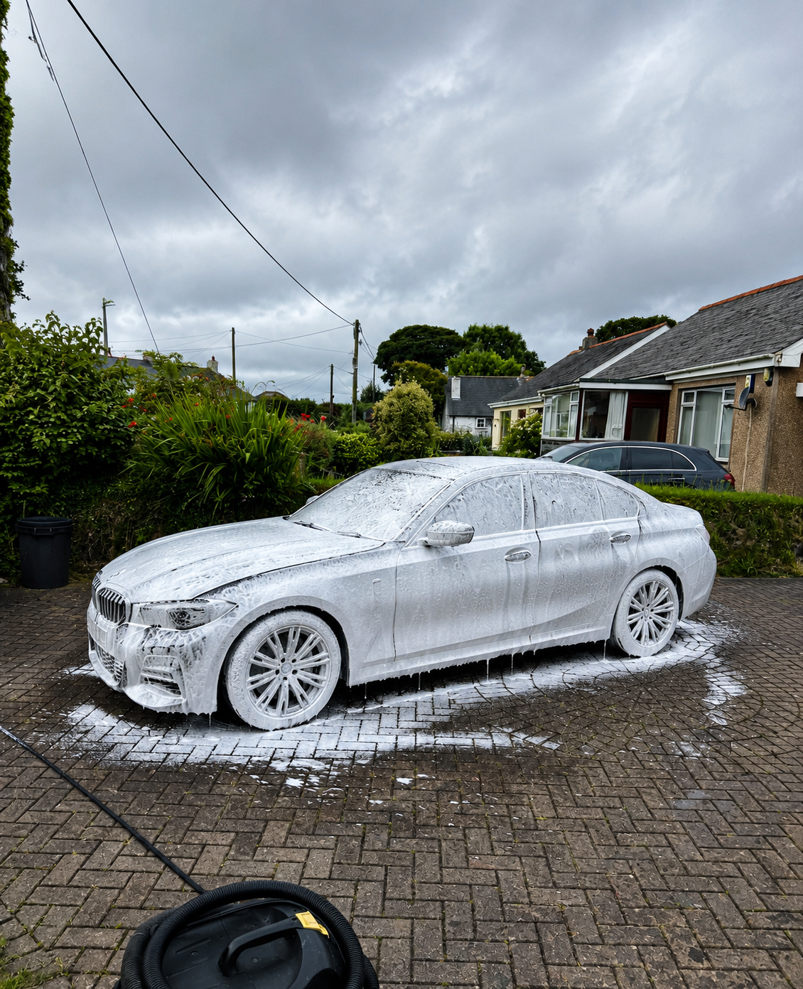 BMW covered in snow foam mid-valet — mobile car wash in Cornwall